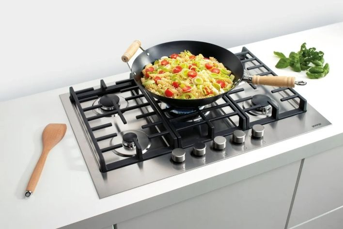 Placa de cocción con sartén y comida casera